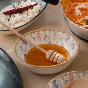 Ahşap kaşıkla servis edilen bal ve yanındaki kaseler